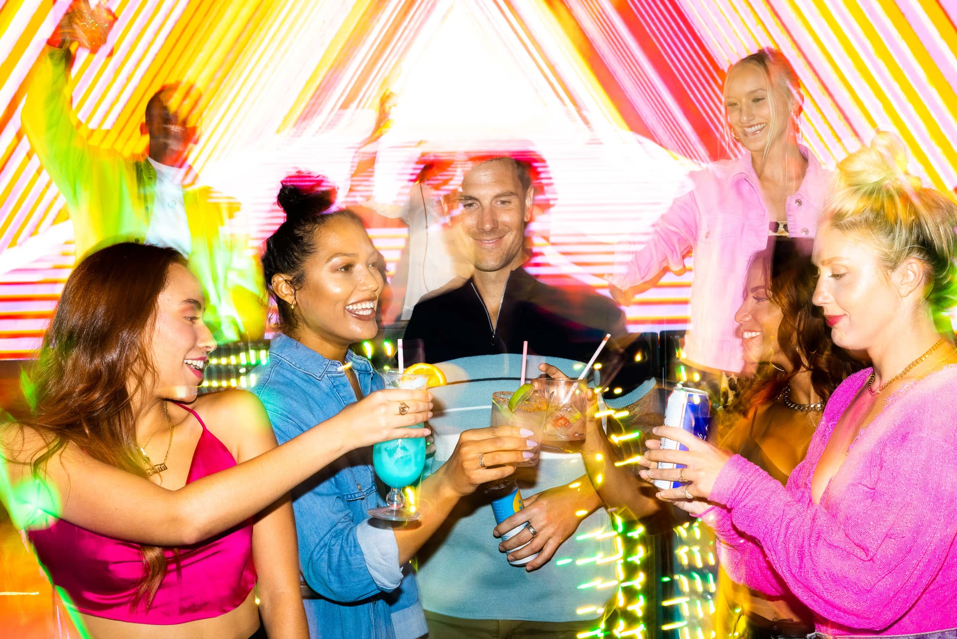 Couple toasting cocktails with friends