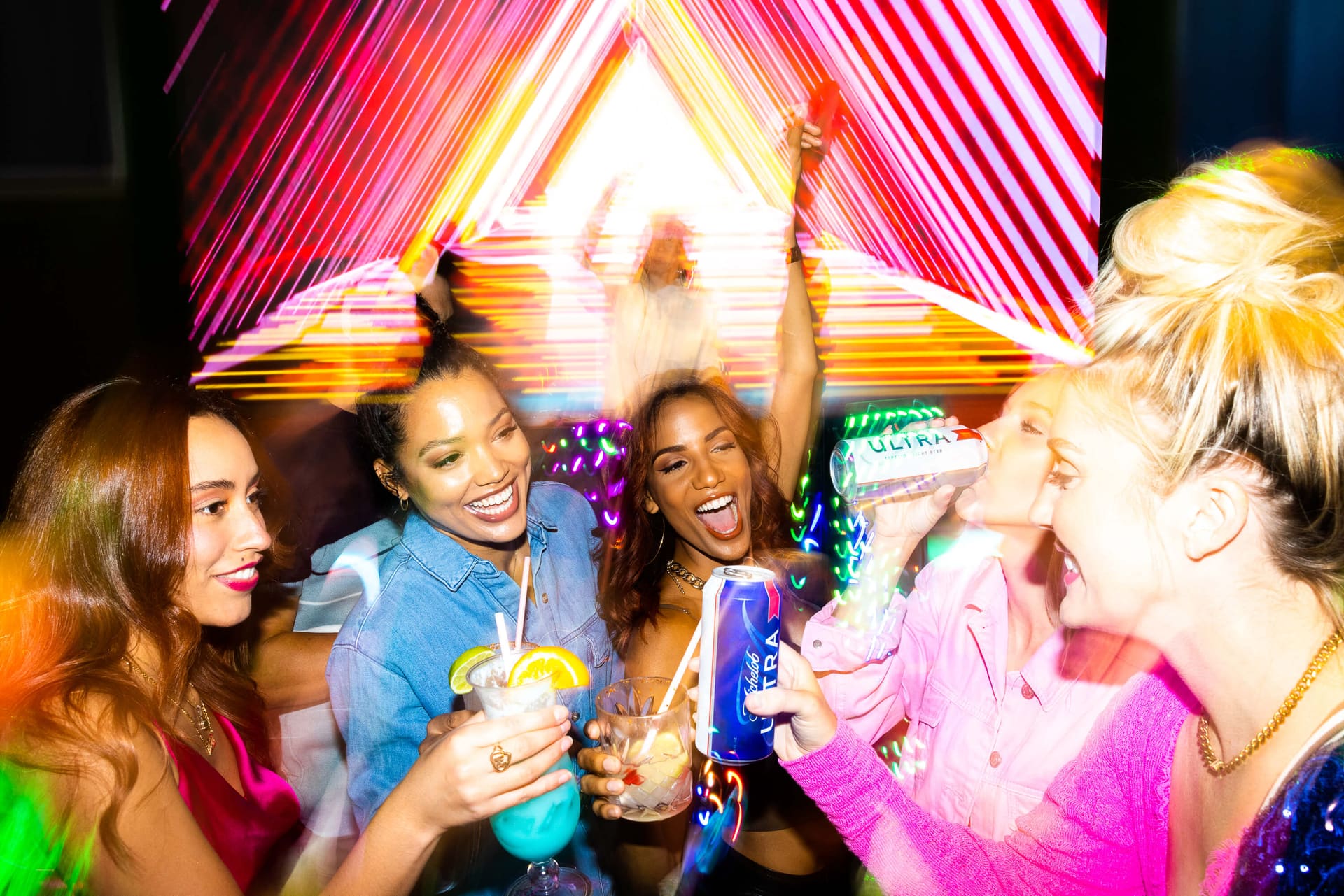 Friends celebrating a birthday under neon lights